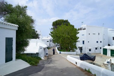 Binibeca, Menorca 'daki sakin bir sokak sahnesinde beyazlatılmış ikonik binalar ve bölgenin büyüleyici mimarisi sergileniyor..