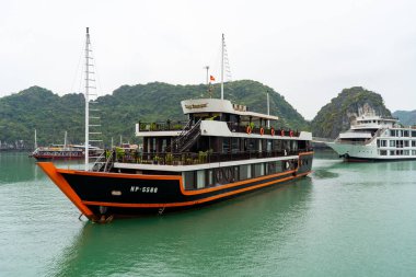Lüks bir yolcu gemisi, Vietnam 'daki Ha Long Körfezi' nin sakin sularında yol alır. Etrafı kireçtaşı karstleri ve diğer teknelerle çevrilidir. Harika bir tatil..