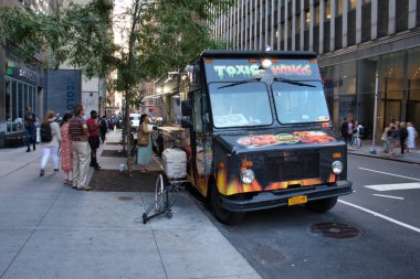 New York 'ta kanat servis eden bir yemek kamyonu. Binaların ve yayaların yakınına park etmiş..