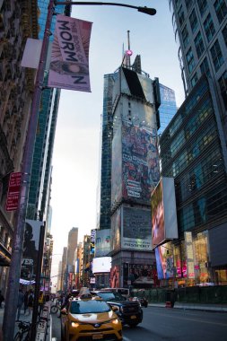 Gündüz çekimleri Times Meydanı, New York City 'nin canlı enerjisini yüksek binalar, reklam panoları ve hareketli bir sokak sahnesiyle yakalıyor..