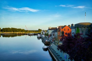 Renkli binaları ve İrlanda, Galway 'de taş bir kalesi olan Corrib Nehri manzaralı..
