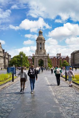 İnsanlar İrlanda, Dublin 'de parlak mavi bir gökyüzünün altında tarihi bir binaya doğru yürüyorlar..
