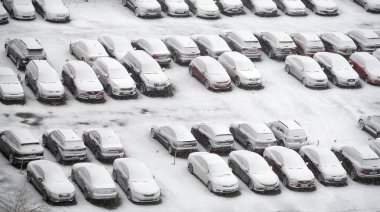 Kyiv, Ukrayna 12 Mart 2023: Otoparktaki arabalar yapışkan karlarla süpürüldü
