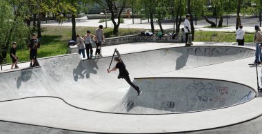 Kyiv, Ukrayna 27 Nisan 2024: Erkekler kaykay ve scooter kullanıyor