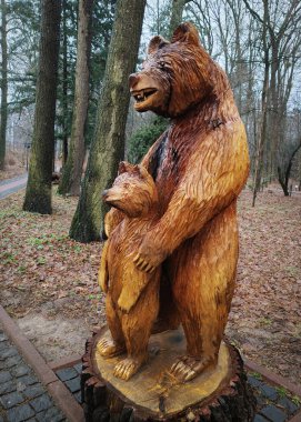 Kyiv, Ukrayna 27 Ocak 2025: Ukrayna Botanik Bahçesi bölgesindeki tek bir odun parçasından oyulmuş yavru ayıyla dişi ayı heykeli