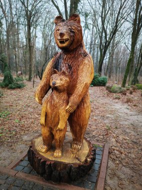 Kyiv, Ukrayna 27 Ocak 2025: Ukrayna Botanik Bahçesi bölgesindeki tek bir odun parçasından oyulmuş yavru ayıyla dişi ayı heykeli
