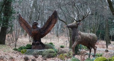 Kyiv, Ukrayna 27 Ocak 2025: Ukrayna Botanik Bahçesi Bilimleri bölgesindeki tek bir odun parçasından bir kartal ve bir geyik heykeli