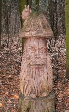 Kyiv, Ukrayna 27 Ocak 2025: Ukrayna Botanik Bahçesi bölgesindeki tek bir tahta parçasından oyulmuş mantar şeklinde yaşlı bir orman adamı heykeli