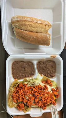 Lezzetli Meksika kahvaltısı chilaquiles rojos con chorizo, huevo ve bolillo.