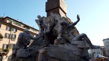 Turistler meydanı barok fıskiyeler ve sokak sanatçılarıyla ziyaret ediyorlar. Berninis Çeşmesi 'ndeki Tanrı Zeus' un ünlü heykeli. Navona Meydanı 'ndaki Dört Nehir Pınarı.. 