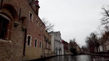Bruges, Belçika 'da büyüleyici tuğla binalarla kaplı ve karmaşık mimari detaylarla süslenmiş tarihi bir kanal manzarası..