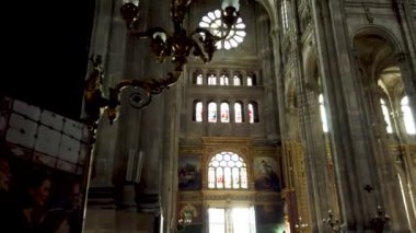 Paris 'teki Saint-Eustache Kilisesi' nin içini gösteren ve çarpıcı gül penceresi ve etrafındaki mimari detaylara odaklanan bir video.