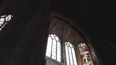 Gotik bir katedralin içini gösteren büyüleyici bir video. Karmaşık vitraylı pencereler güneş ışığıyla yıkanmış.