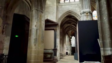 Yüksek kubbeli tavanlar, kemerli sütunlar ve vitray pencerelerin yer aldığı tarihi bir kilisenin iç mekanı.. 