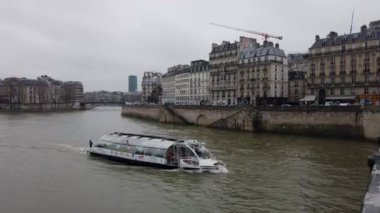 Paris, Fransa 'dan geçen Seine Nehri' nin videosu. Nehir, binalar ve köprüler ile kaplı ve suda yüzen bir tekne var.. 