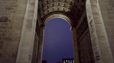 Paris, Fransa 'daki Zafer Takı' nın görkemli manzarası, derin mavi gökyüzüne karşı aşağıdan aydınlatılmış..