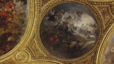 Fransa 'nın Versailles Sarayı' ndaki çarpıcı tavan tablosunun yakından görüntüsü. Karmaşık detaylar ve zengin renkler içeriyor..