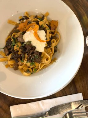 Bu fotoğrafta bol ragu ya da et sosuyla servis edilen muhtemelen tagliatelle olan rahatlatıcı bir tabak makarna var.