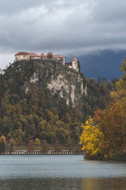 Slovenya 'nın Bled gölündeki ikonik kalenin panoramik görüntüsü. Zümrüt suları ve görkemli bir dağ zeminiyle çevrili..