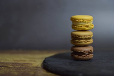 Makarnalar kahverengi ve sarı tonlarda levha ve siyah zemin üzerine istiflenmiş..