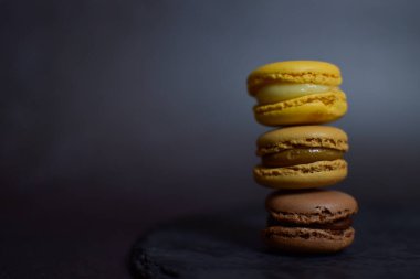 Siyah zemin aydınlatmalı, kahverengi ve sarı badem kurabiyesi kulesi.