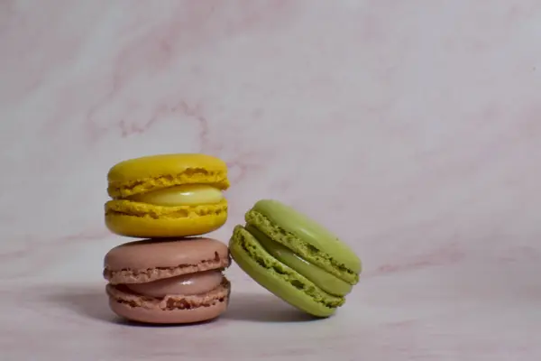 Drie Gele Roze Groene Macarons Roze Marmer — Stockfoto