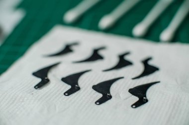 Bir grup sökülmüş kamera lensi ve lens tamir aletleri yeşil servis masasında tamir ve temizlik için bekliyor.