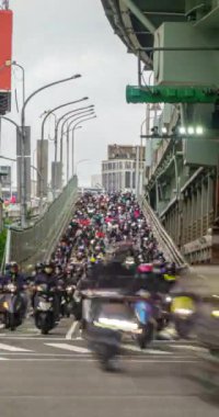 Taipei Taiwan, Aralık-19-2023: Taipei-Tayvan trafiğinin yoğun olduğu saatlerde köprüden şelale gibi inen bir sürü scooter ve motosiklet dikey zaman çekimi