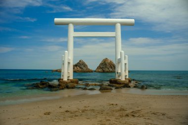 Sakurai Futamigaura beyaz torii kapısı Itoshima, Fukuoka, Kyushu, Japonya 'daki kayaların önünde.