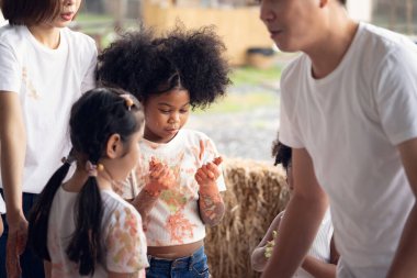 Bir grup çocuk ellerinde renkli su renkleri ve renk lekeleri oynuyor. Okulda mutlu çocuklar oynuyor ve sulu boya resim yapıyor..