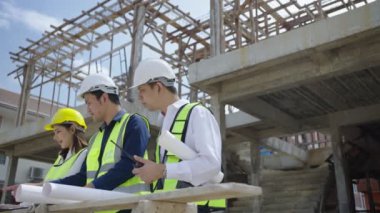 Teams of engineers and architects, watching the Blueprint and planning the construction of the building on the construction site.