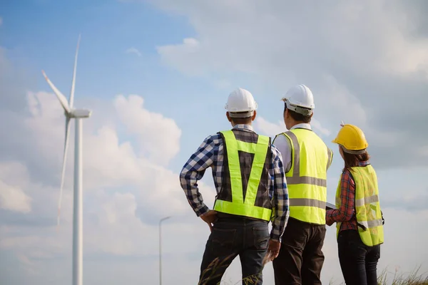 Visão Traseira Três Engenheiros Discutindo Verificando Turbinas Parque Eólico Tecnologia Fotografia De Stock