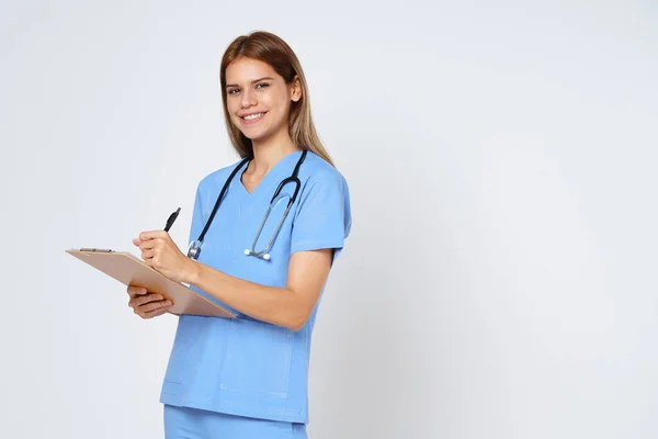 stock image Portrait of smiling woman doctor taking notes making medical with clipboard isolate over white background.