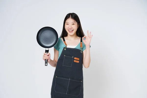 stock image Restaurant owner sme woman showing OK sign and holding pan isolated on white background.