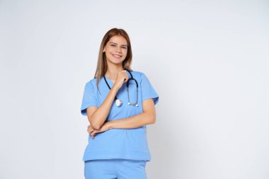 Mavi ceketli gülümseyen kadın doktor portresi beyaz arka planda tek başına duruyor..