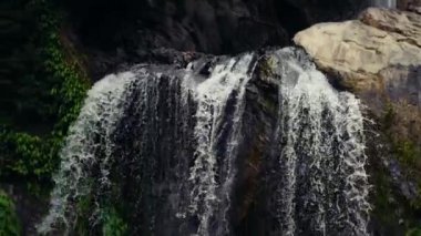 Close up waterfall water splashing on rocks.