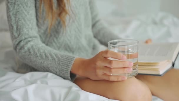 Ung Asiatisk Kvinna Dricker Vatten Medan Läser Bok Som Sitter — Stockvideo
