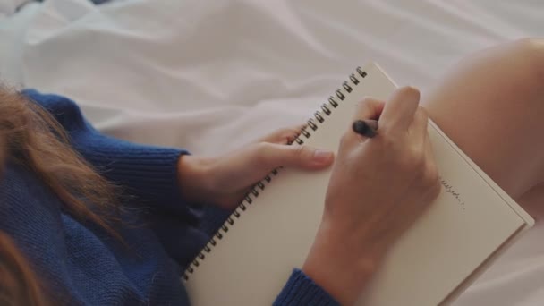Zamknij Się Młoda Kobieta Siedzi Wygodnym Łóżku Robi Notatki Pamiętnika — Wideo stockowe