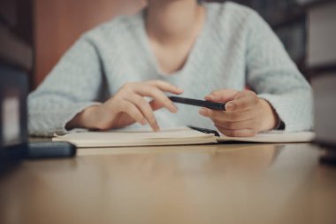 Öğrenci üniversite sınavına hazırlanıyor, sınav, kitap okuyor, ders kitabı okuyor, notlar yazıyor, sınıf ödevi için özet yapıyor. Çalışma masası öğrenmek, ellerinizi kalemle kapatın.