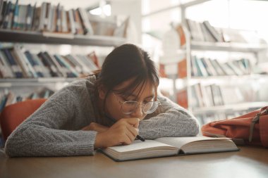 Sıkıcı öğrenci kız kitap okuyup yalan söylüyor sıkıcı derste kendini yorgun ya da depresif hissediyor..