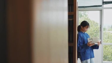 Öğrenci kız kütüphanede kitap okuyor. Eğitim ve öğrenme kavramı.