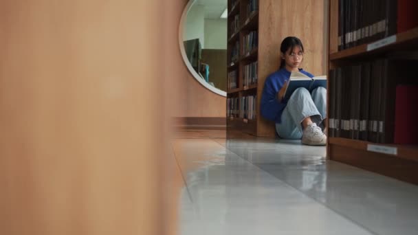 Studentessa Seduta Sul Pavimento Lettura Libro Biblioteca Preparazione Esame Concetto — Video Stock