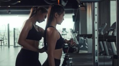 Genç Asyalı kadın spor salonunda egzersiz yapıyor, kişisel antrenörle kaslarını ve gücünü güçlendirmek için egzersiz yapıyor. Spor salonunda spor yapmak..