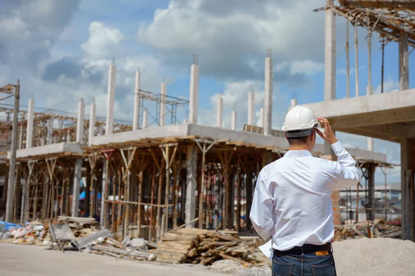 Stock image Engineer working and checking plan on construction site.