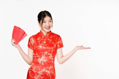 Geleneksel Cheongsam Qipao elbisesi giyen Asyalı kadın bir şey gösteriyor ve beyaz arka planda Angpao ya da kırmızı paket hediye taşıyor. Mutlu Çin Yeni Yılı.