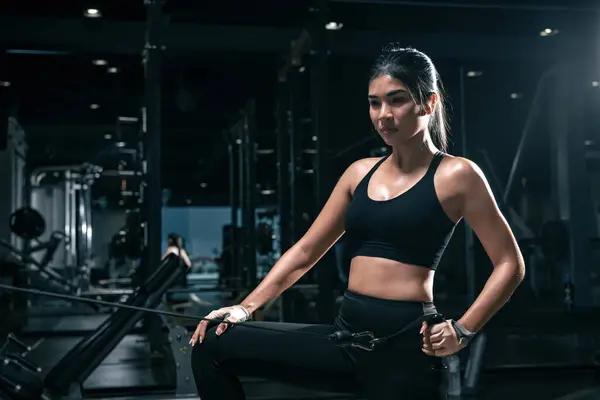 stock image Sporty woman exercising on multistation at gym for arm and shoulders muscles. Fitness exercising in gym.