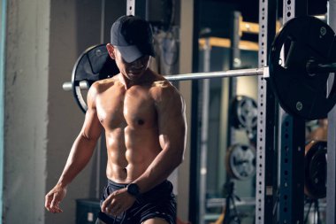 Sportif vücut geliştirici ya da halterci spor salonunda halterle ağırlık kaldırma egzersizi yapıyor. Spor salonunda spor yapmak..