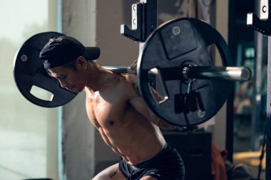 Sportif vücut geliştirici ya da halterci spor salonunda halterle ağırlık kaldırma egzersizi yapıyor. Spor salonunda spor yapmak..