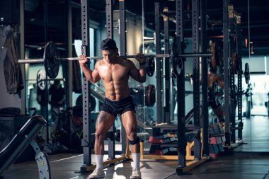 Sportif vücut geliştirici ya da halterci spor salonunda halterle ağırlık kaldırma egzersizi yapıyor. Spor salonunda spor yapmak..