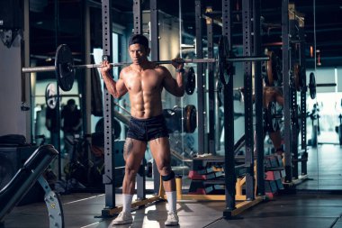 Sportif vücut geliştirici ya da halterci spor salonunda halterle ağırlık kaldırma egzersizi yapıyor. Spor salonunda spor yapmak..